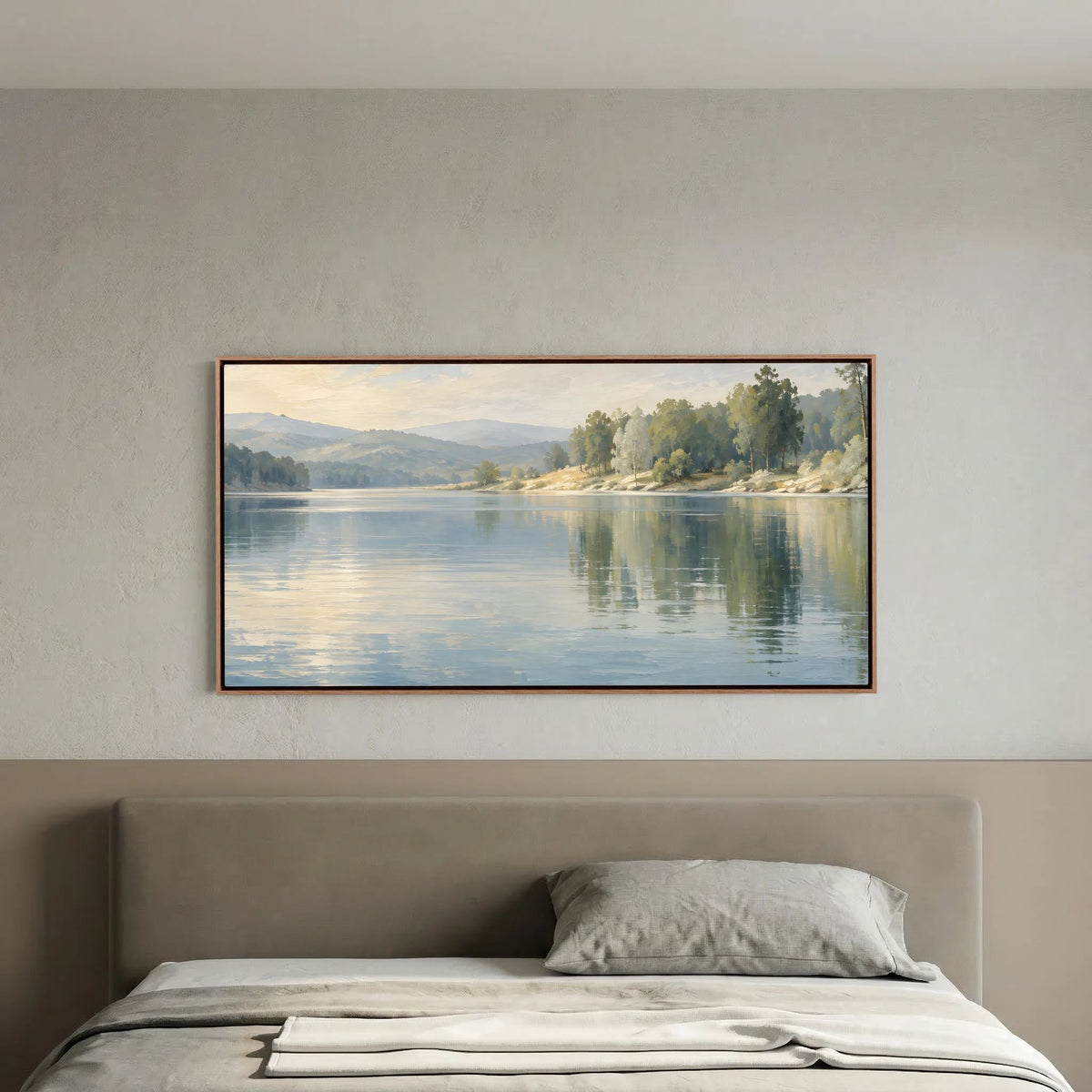 Tela de paisagem de lago Stillwater Reflection sobre uma cama num quarto ilustrativo em tons neutros.